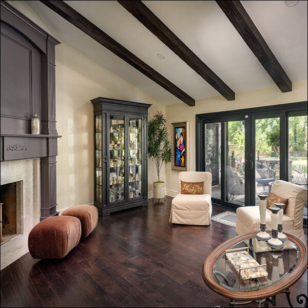 Remodeled Santa Clarita living room with raised dark wood floor, exposed beams and black-framed doors