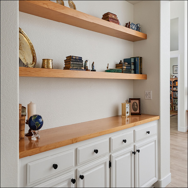 After: Built-in cabinetry and floating wood shelves create a cohesive display and storage space