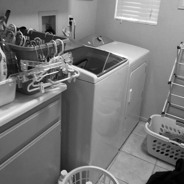 Before: Cramped laundry room with limited counter space and storage