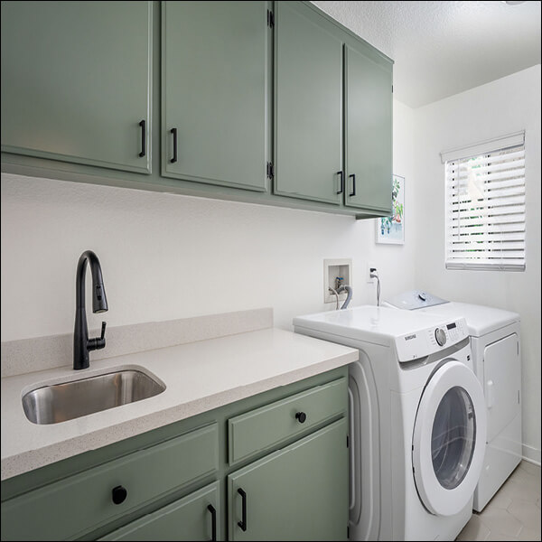 After: Refreshed laundry room with generous cabinetry, utility sink, and dedicated workspace