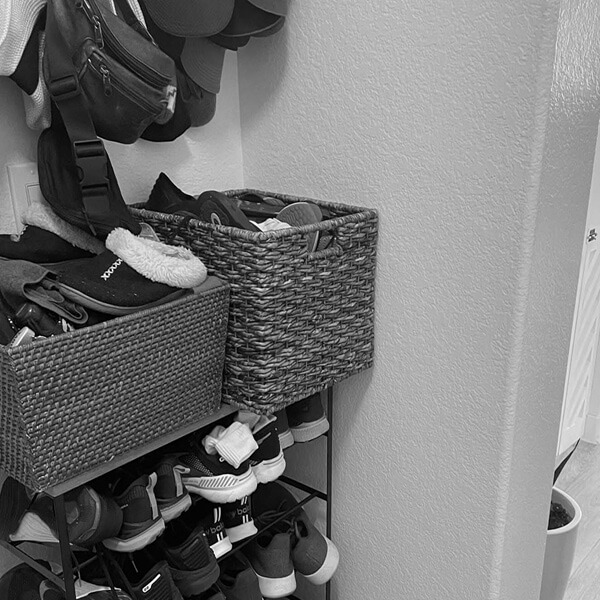 Before: Entryway shoe storage relying on freestanding racks and baskets