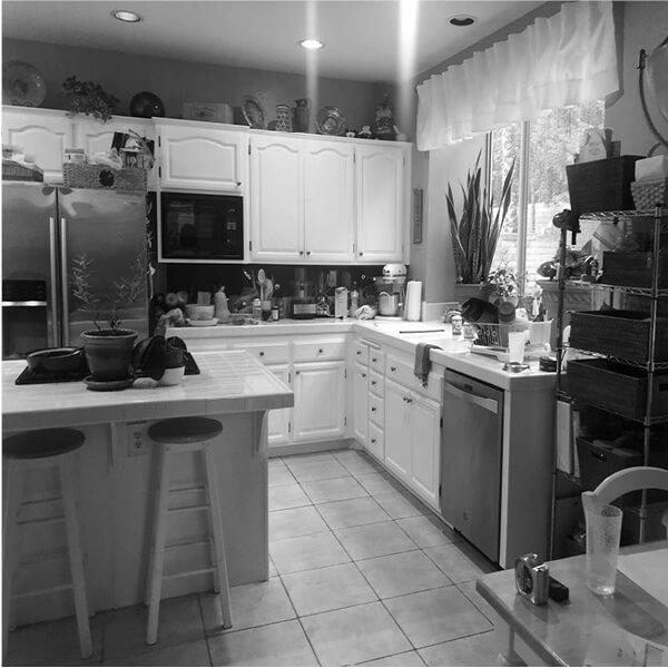 Before: Original Palmdale kitchen with white cabinetry, crowded countertops, and tile flooring